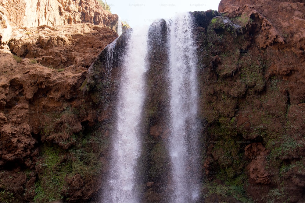 a large waterfall in the middle of a rocky area