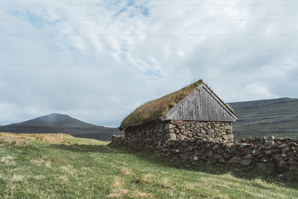 un muro di pietra con un tetto in erba e un tetto in erba