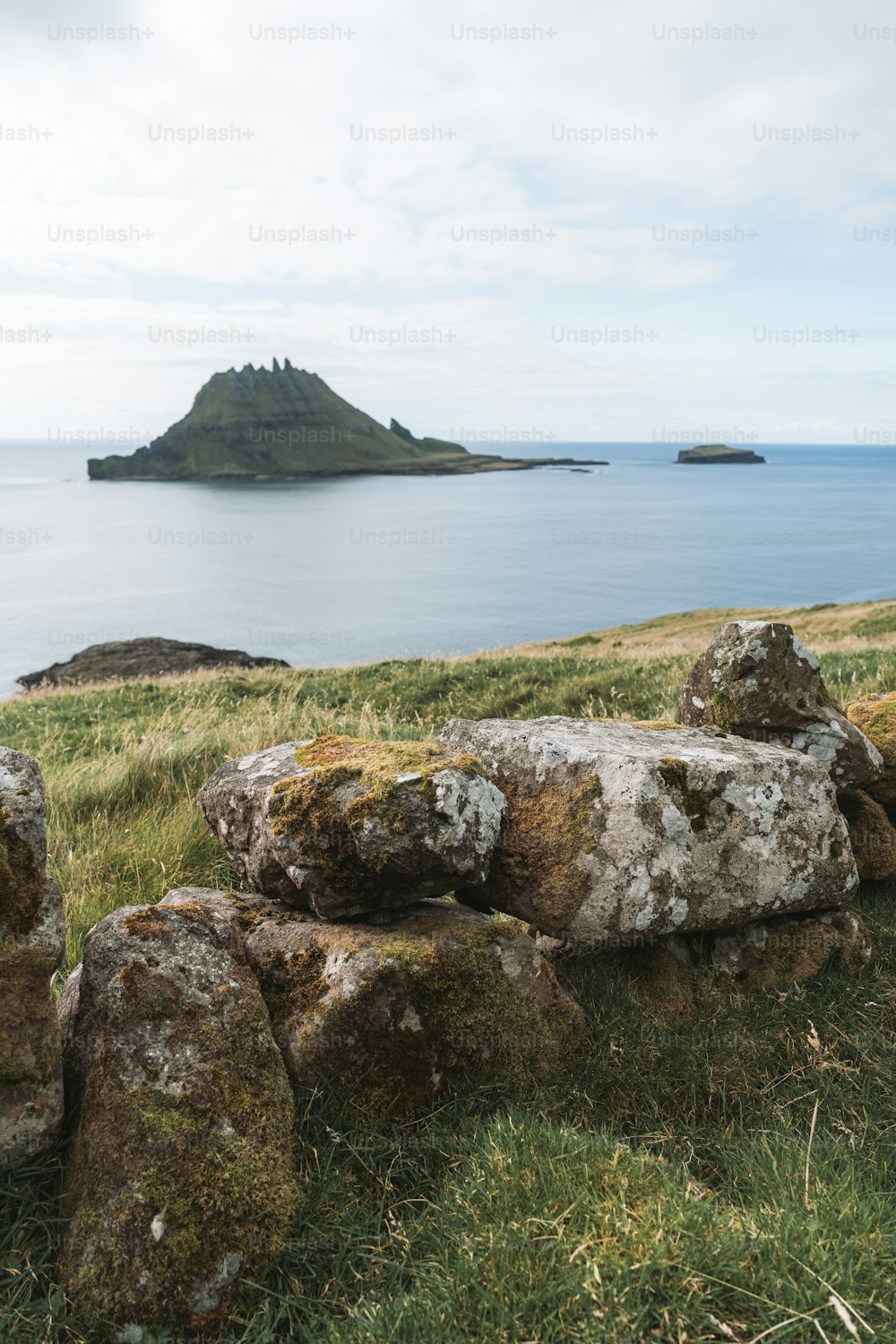 a stone bench sitting on top of a lush green hillside