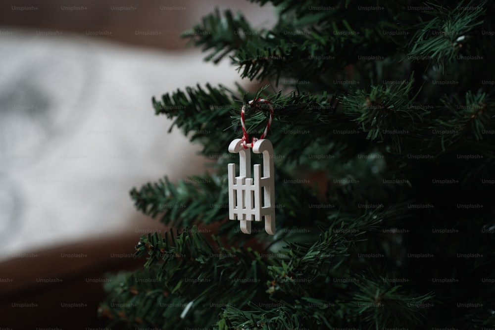 a white ornament hanging from a christmas tree