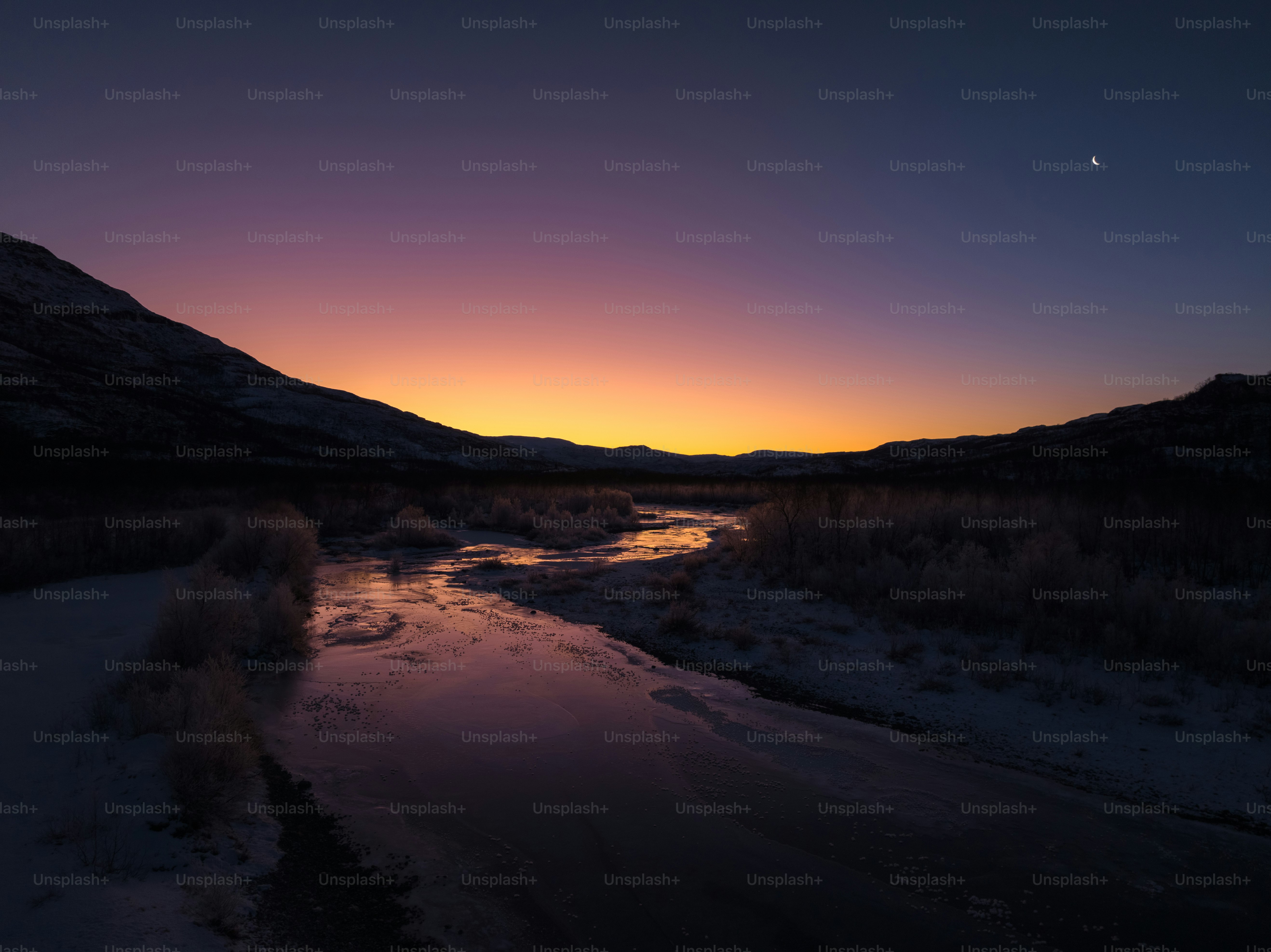 a river running through a dry grass covered field