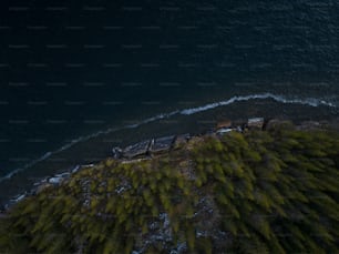 an aerial view of a train on a track next to a body of water