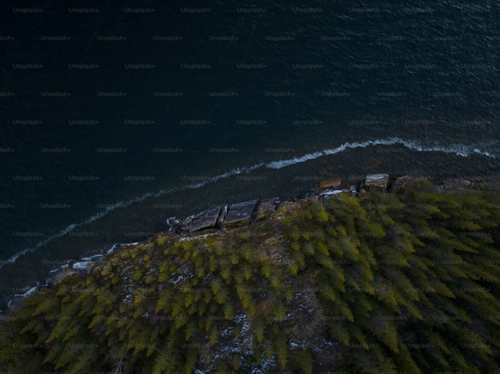 an aerial view of a train on a track next to a body of water