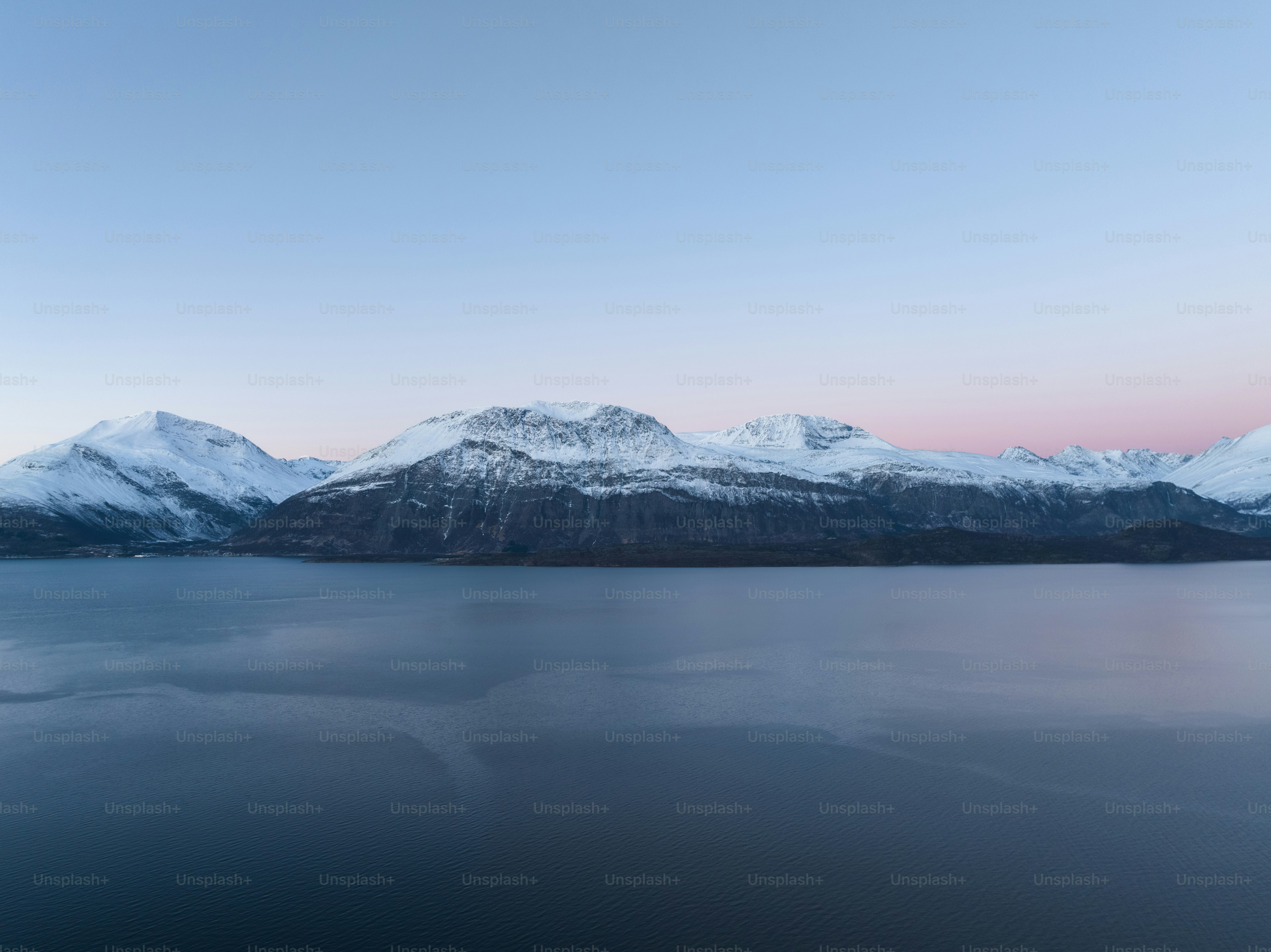 a large body of water surrounded by snow covered mountains