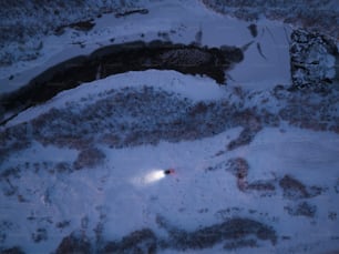 a snow covered field with a light in the middle of it