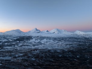 une vue d’une chaîne de montagnes enneigée au coucher du soleil