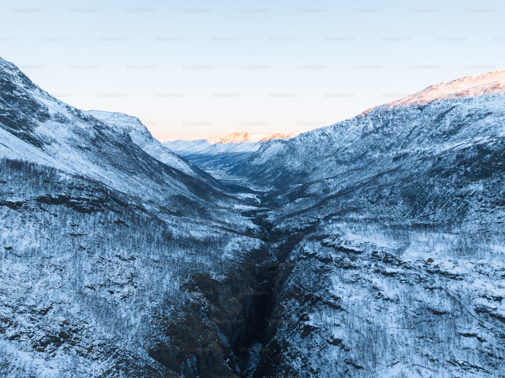 una vista di una valle tra le montagne coperte di neve