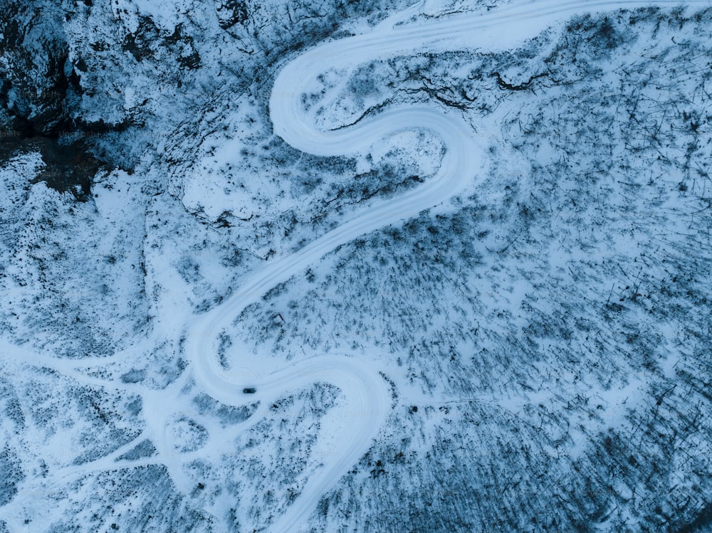 an aerial view of a winding road in the snow