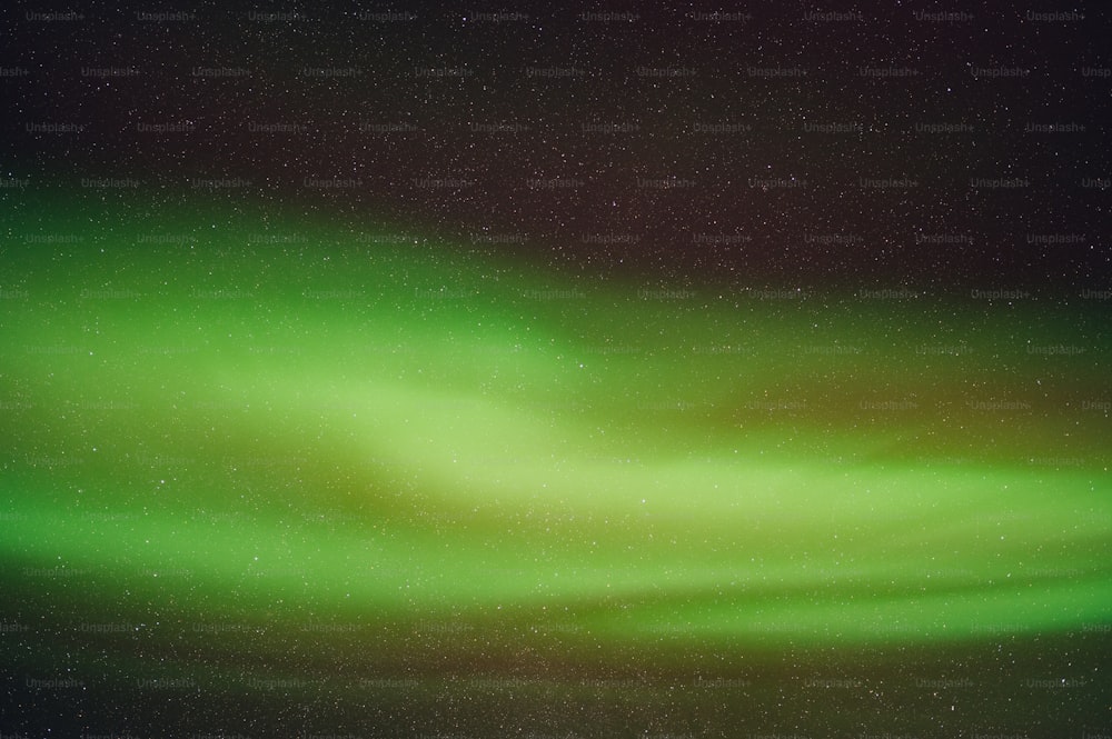 a bright green aurora bore is seen in the night sky