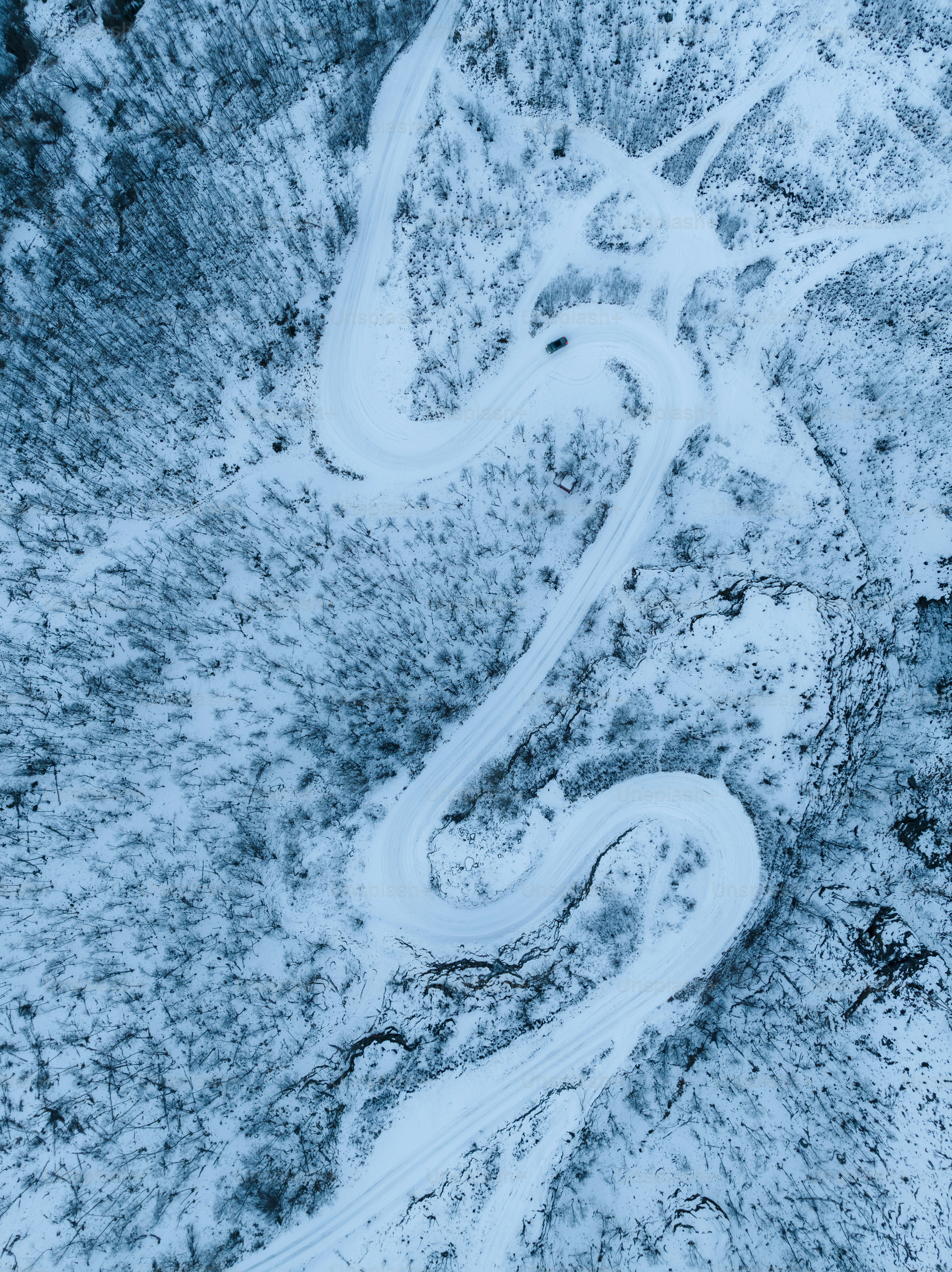 An aerial view of a winding road in the snow photo – Snowy road Image ...