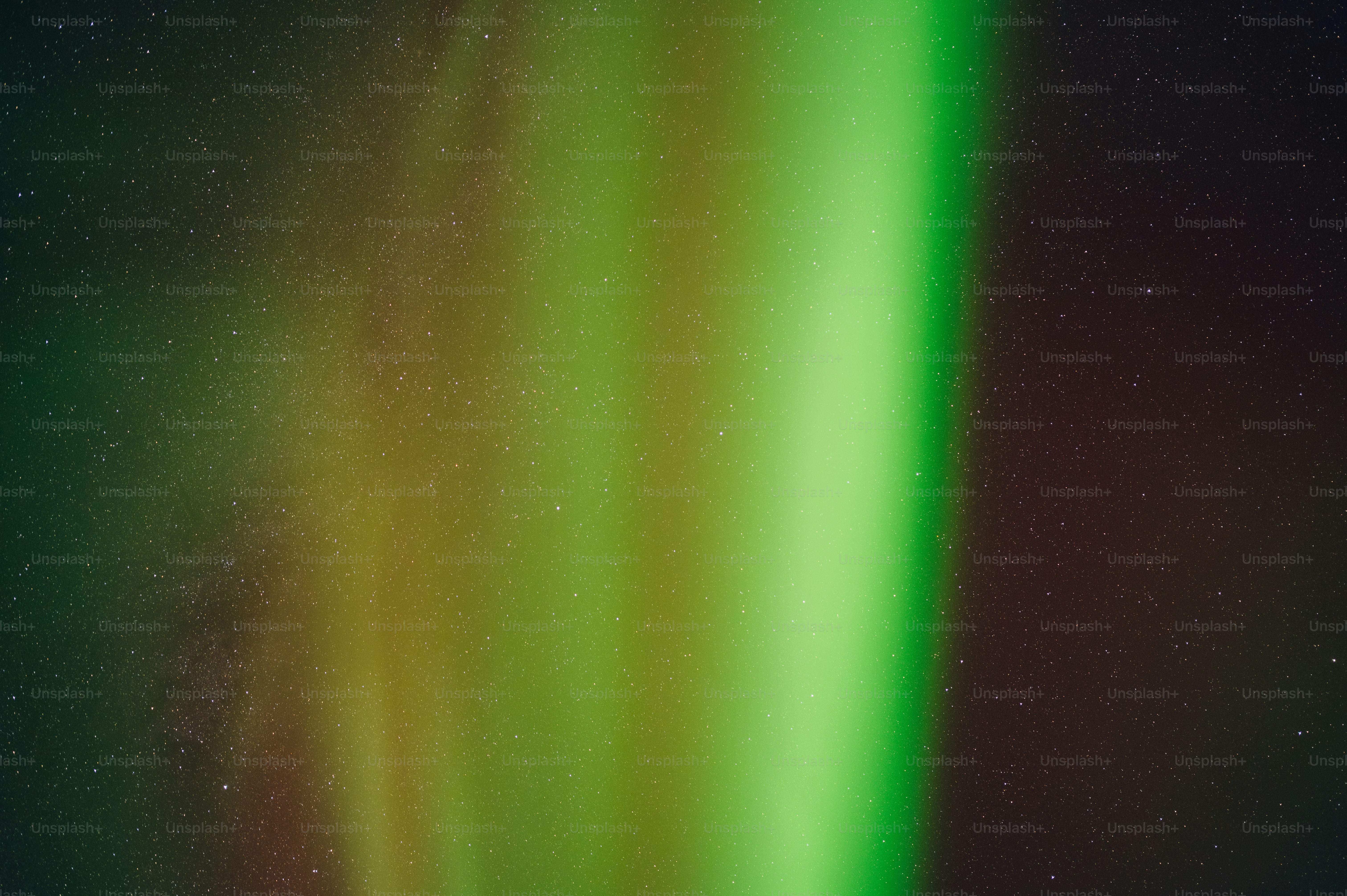 a green and yellow light is shining in the sky