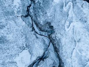 an aerial view of a stream in the snow