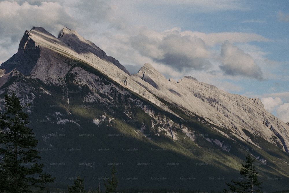 a mountain covered in snow under a cloudy sky