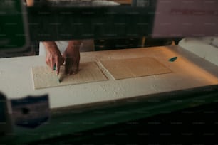 a person cutting up a piece of wood with a knife