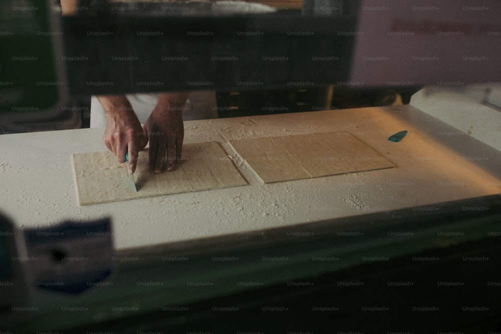 a person cutting up a piece of wood with a knife