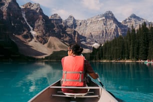 Una persona in una barca su un lago con le montagne sullo sfondo
