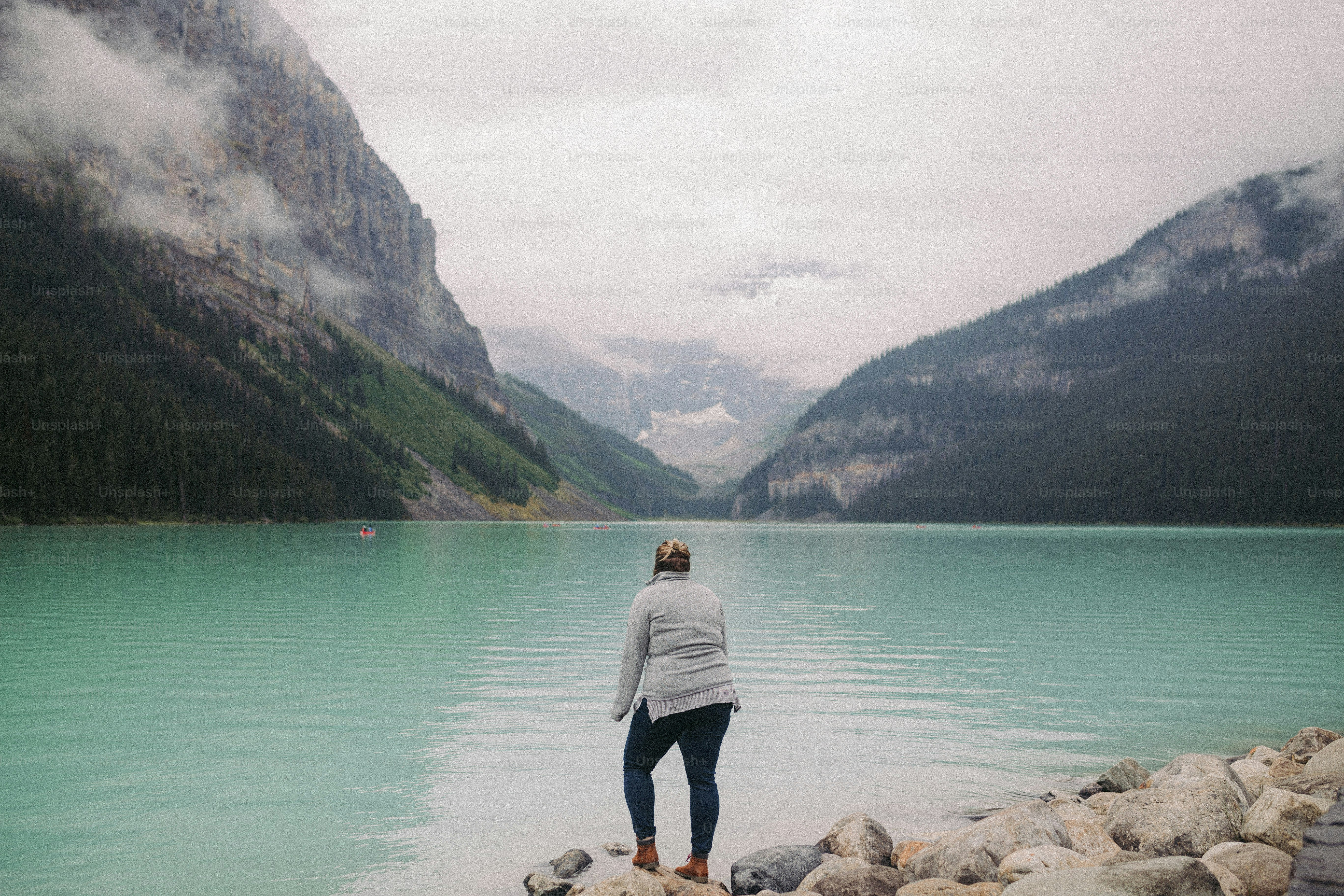a person standing on a rock near a body of water