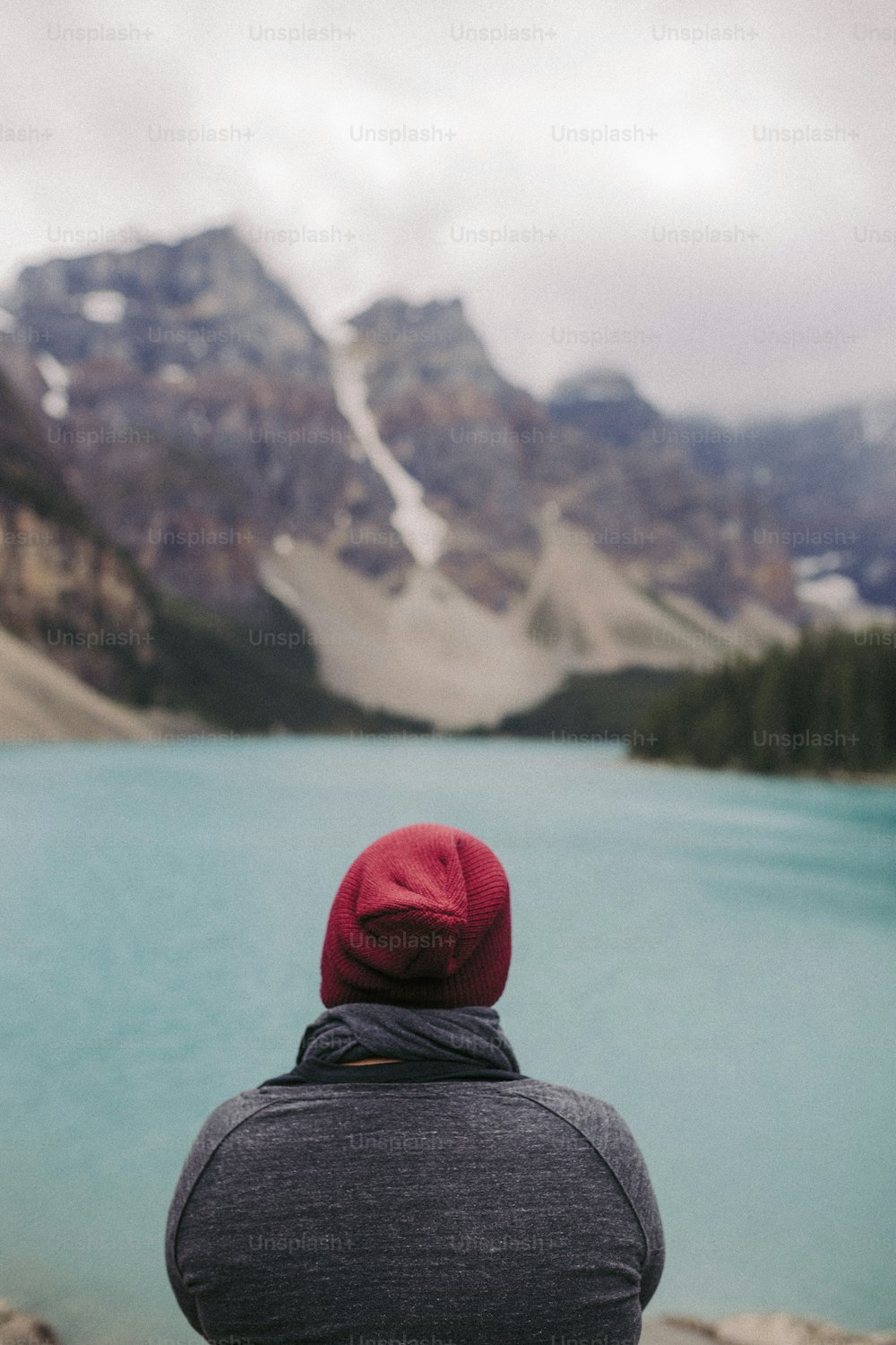 湖を見つめる赤い帽子をかぶった人