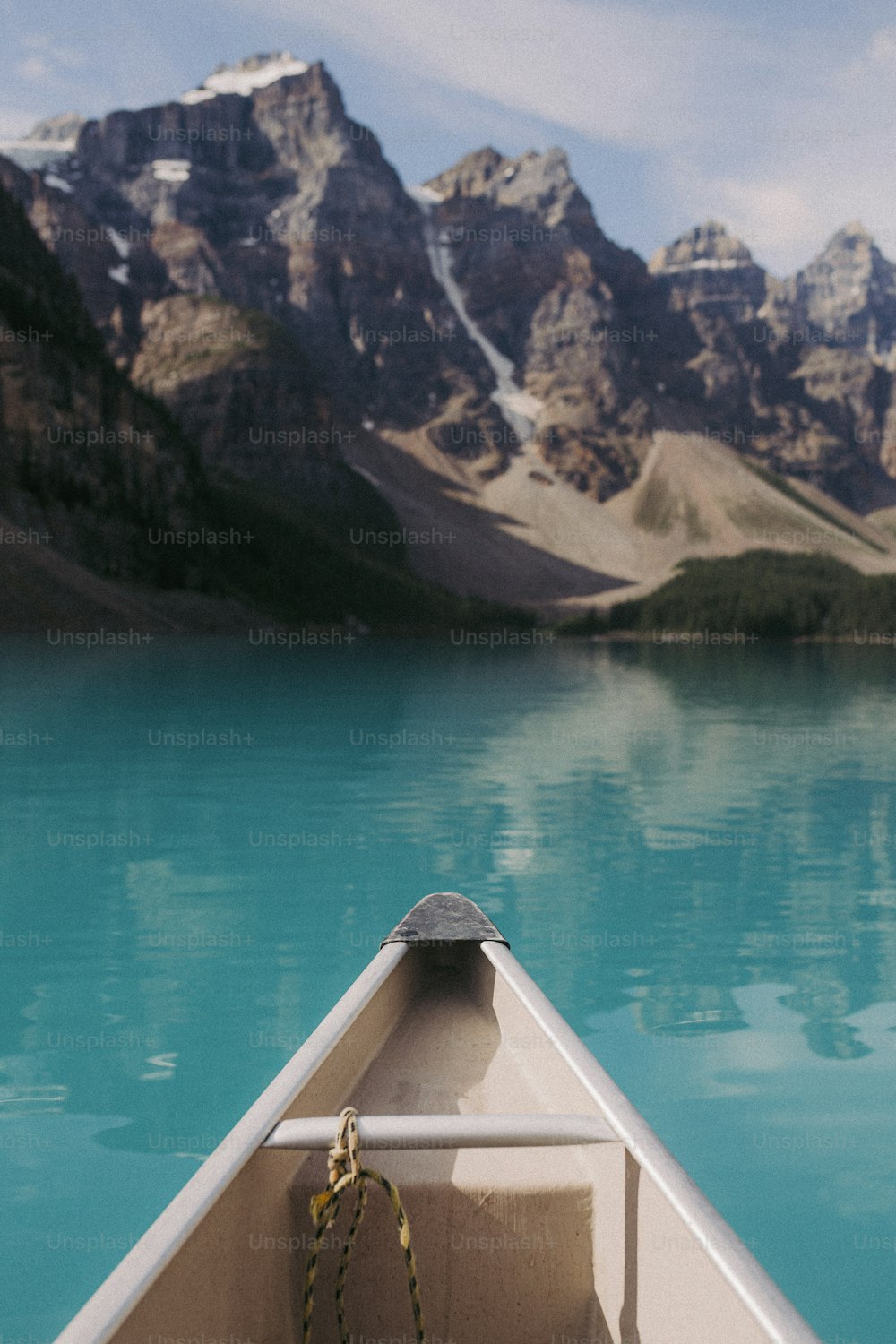 a boat floating on a lake with mountains in the background