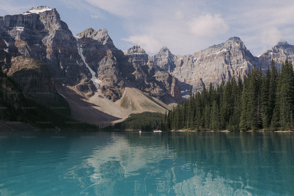 Um lago rodeado por montanhas e pinheiros