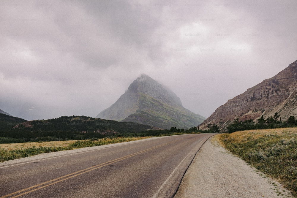 an empty road with a mountain in the background
