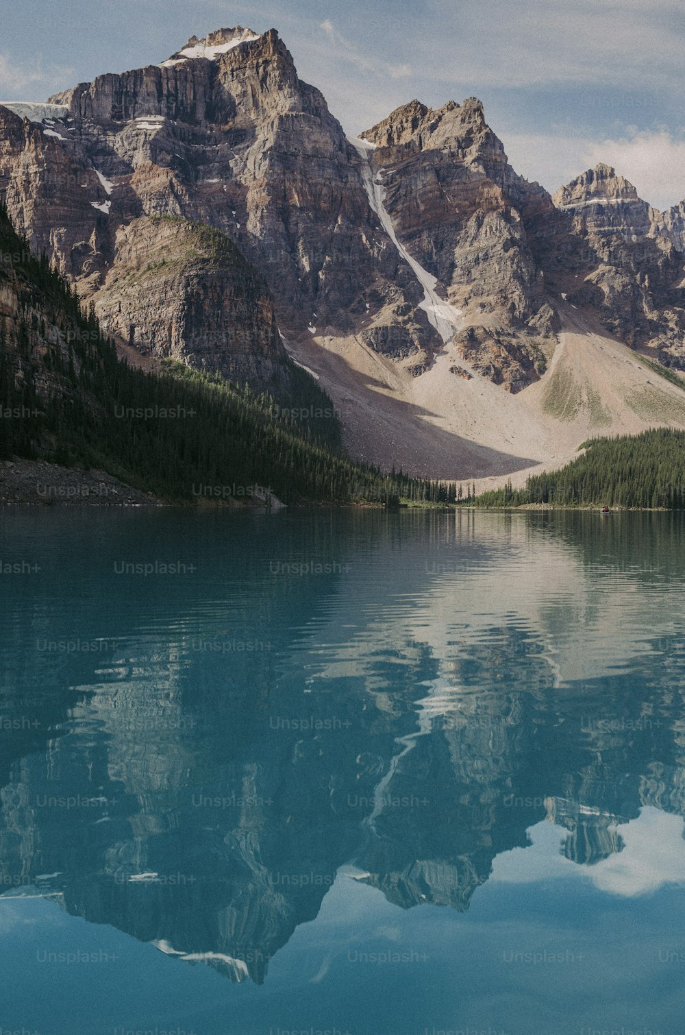 Una catena montuosa si riflette nell'acqua ferma di un lago