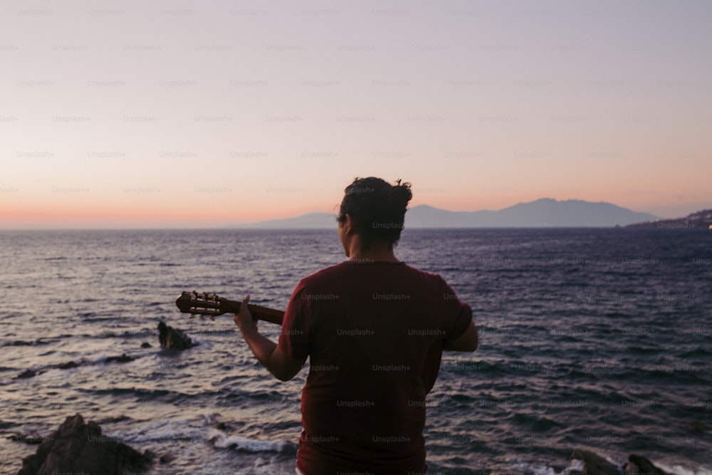 Un uomo che suona una chitarra sulla spiaggia