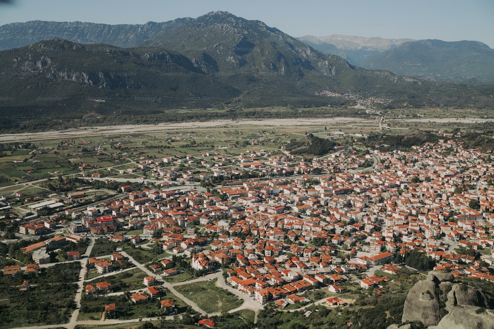 an aerial view of a city with mountains in the background