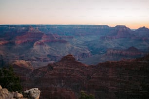 a person sitting on a rock at the edge of a cliff