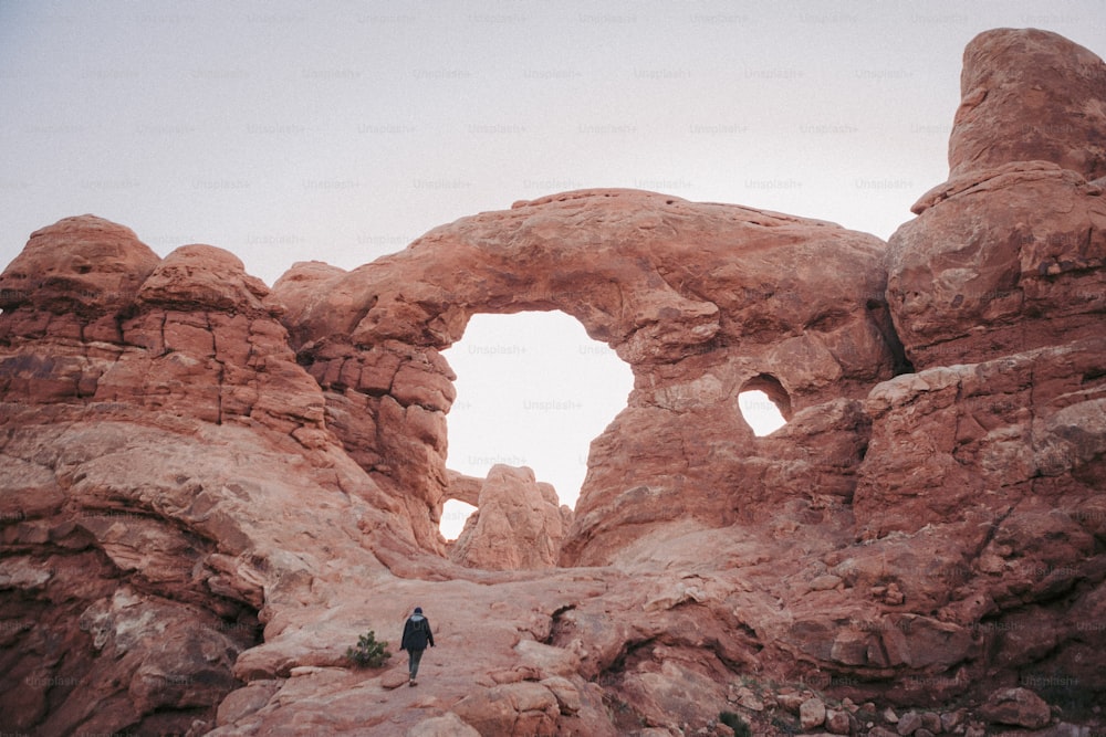 a person standing in a rocky area with a hole in the rock