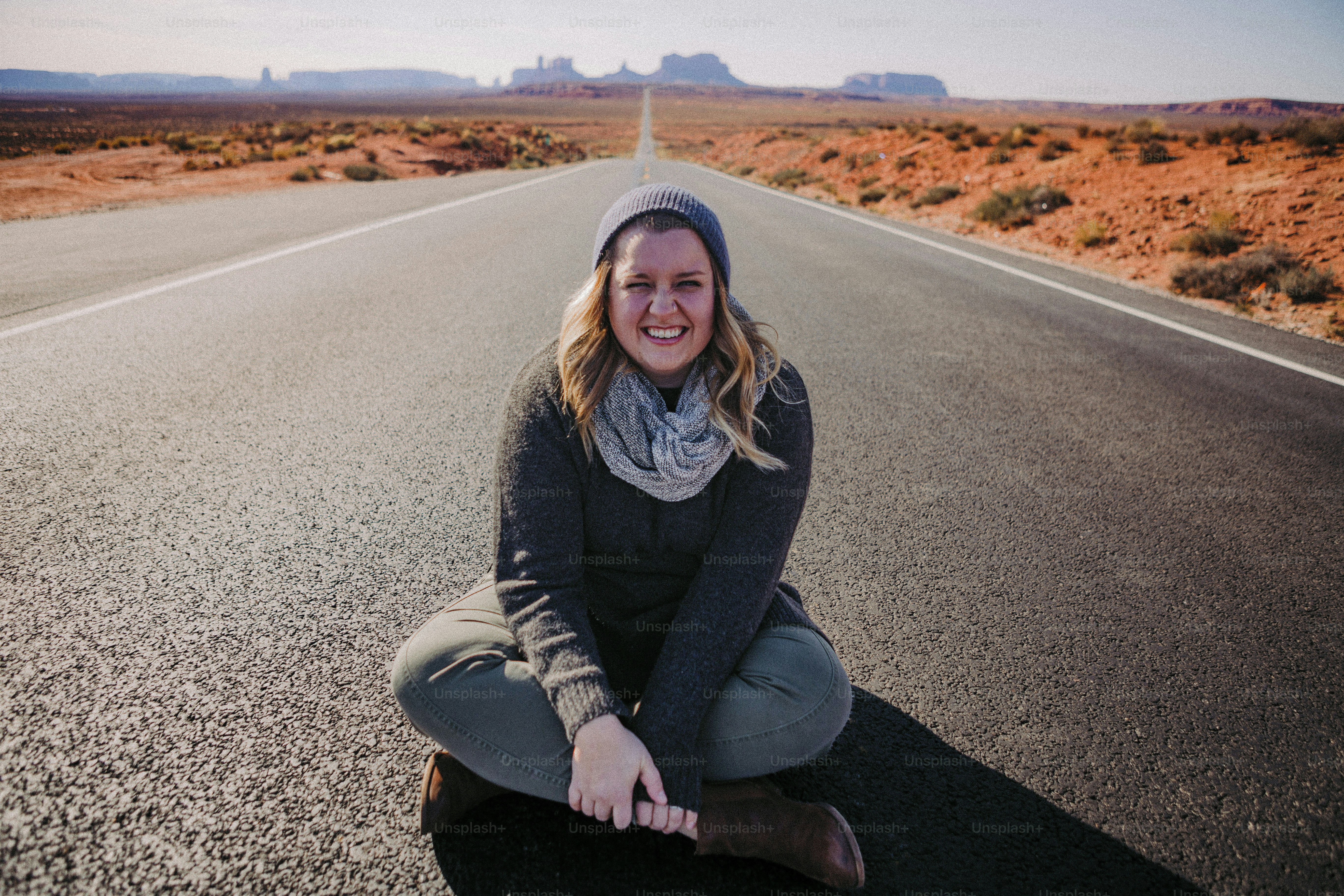 Una donna è seduta sul ciglio della strada