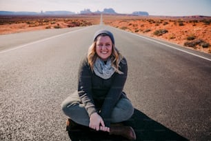 a woman is sitting on the side of the road
