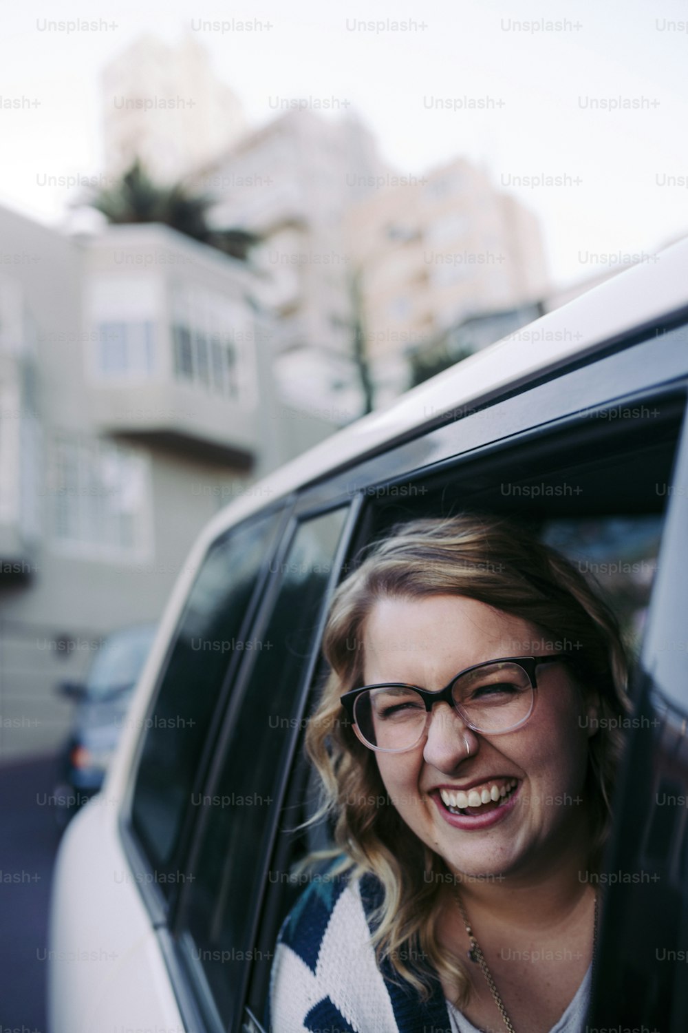 a woman with glasses sitting in a car