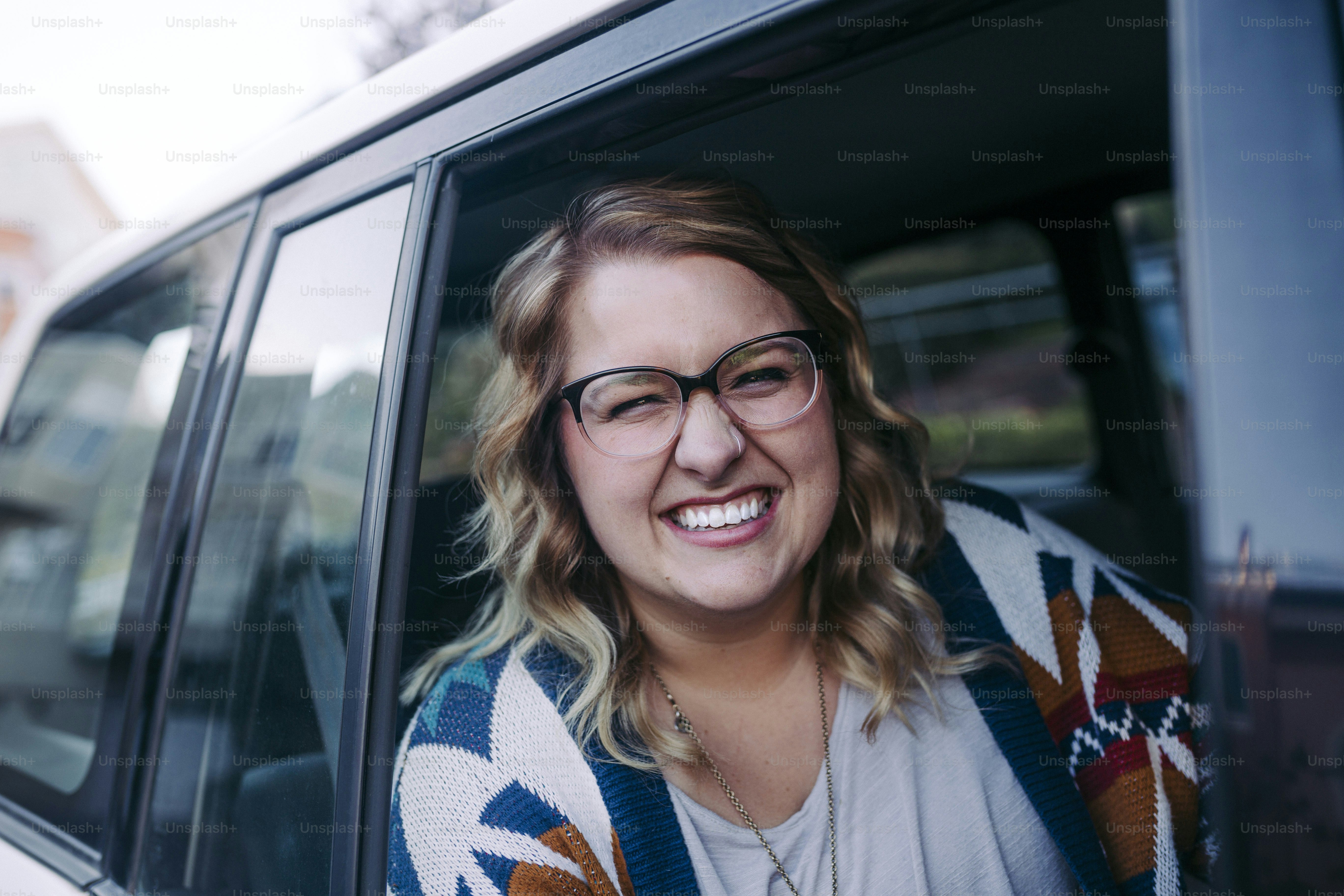 une femme portant des lunettes assise dans une voiture