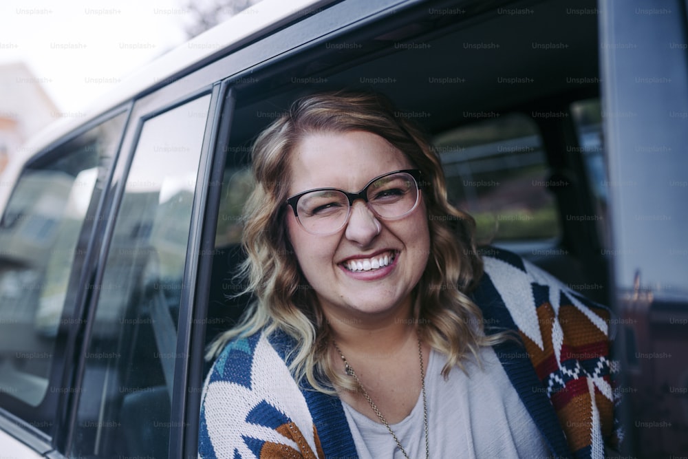 Una mujer con gafas sentada en un coche