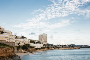 a view of a beach with buildings on the cliff