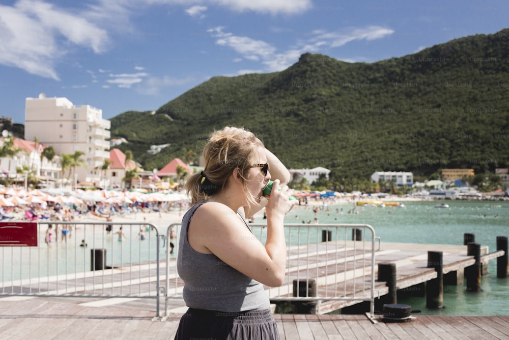 a woman standing on a pier talking on a cell phone