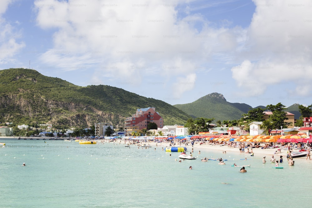 a crowded beach with a mountain in the background