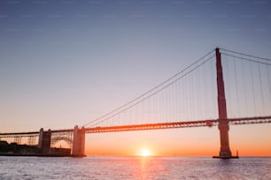 the sun is setting over the bay bridge