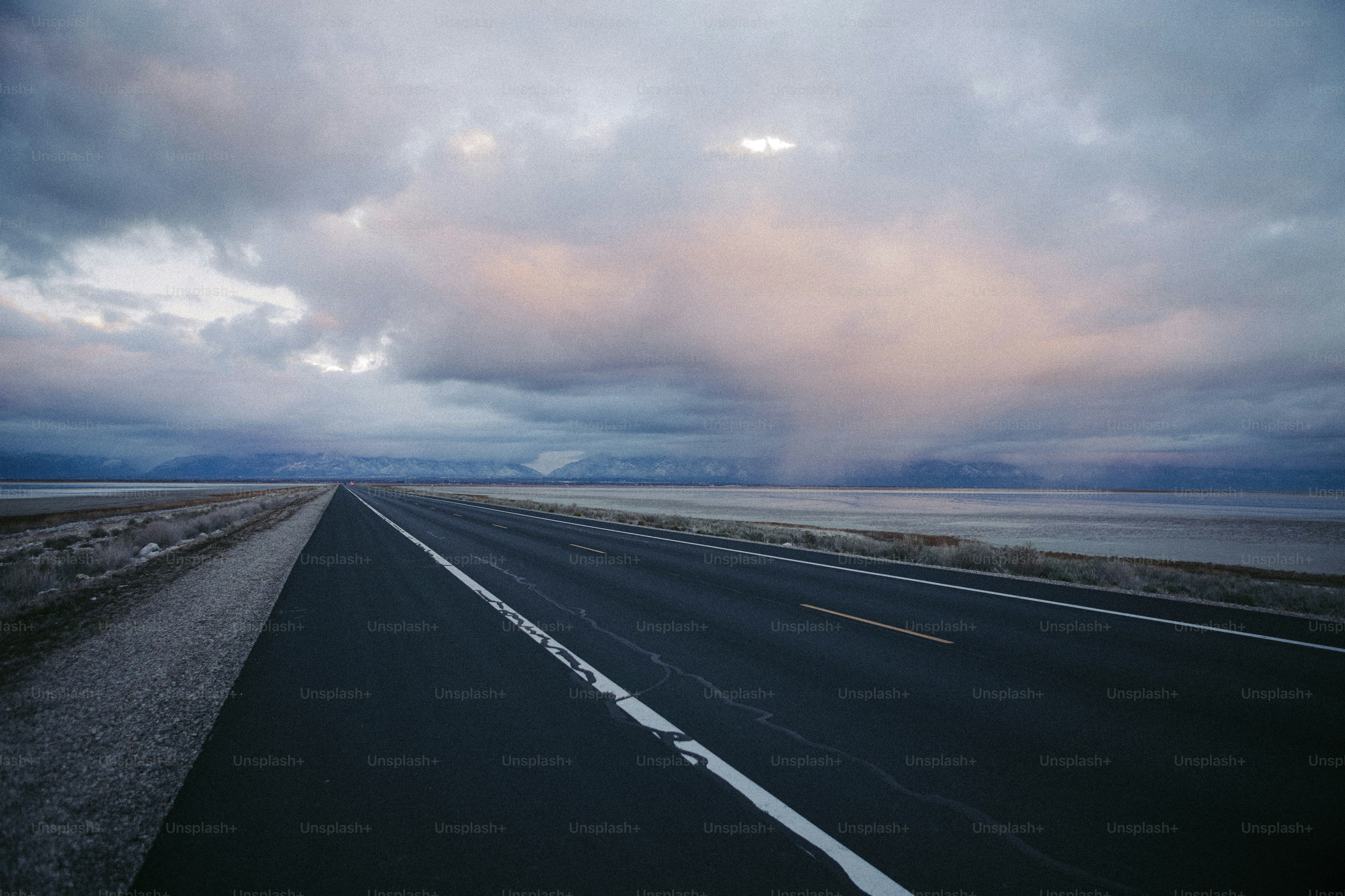 an empty highway with a cloudy sky in the background