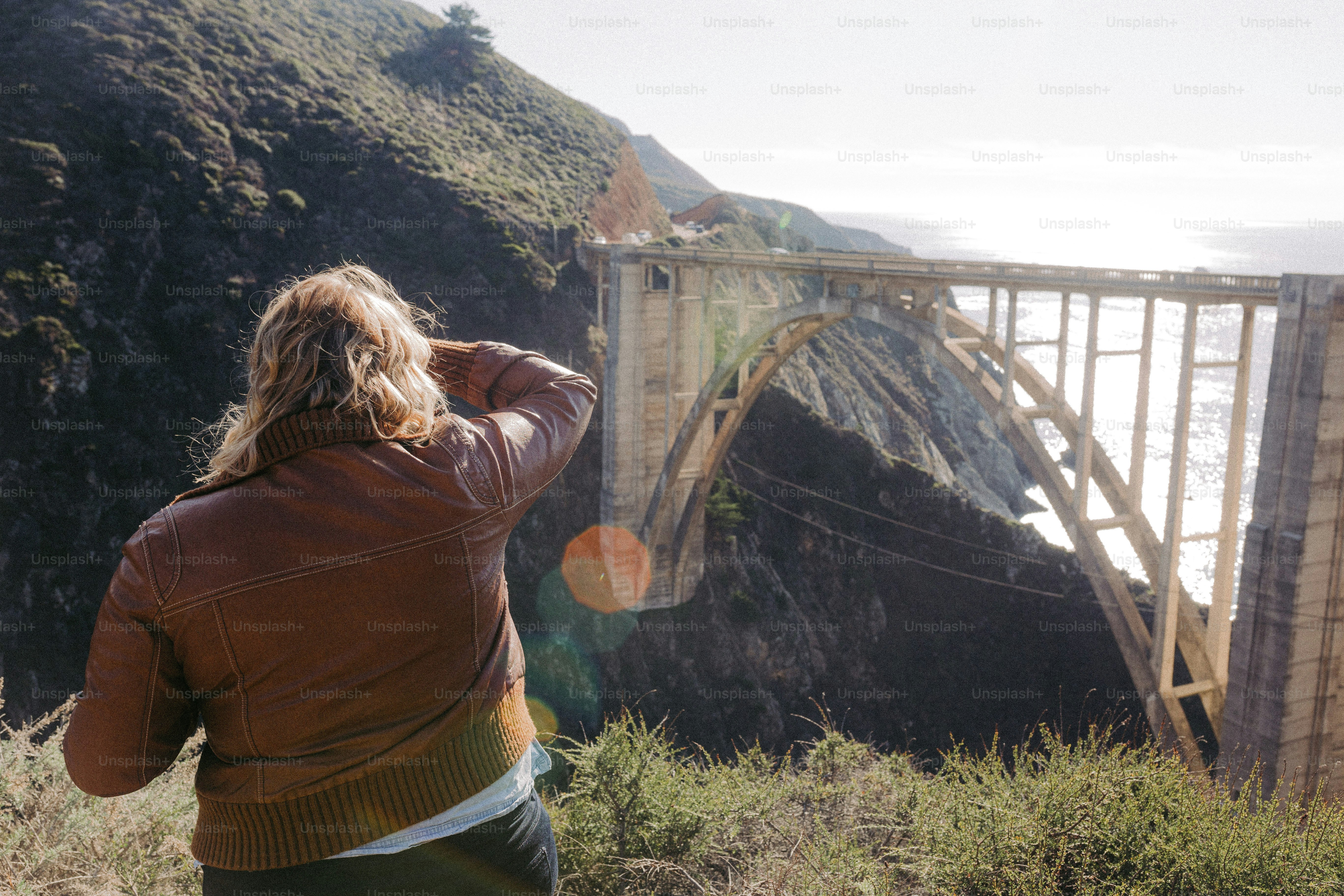 a woman is taking a picture of a bridge