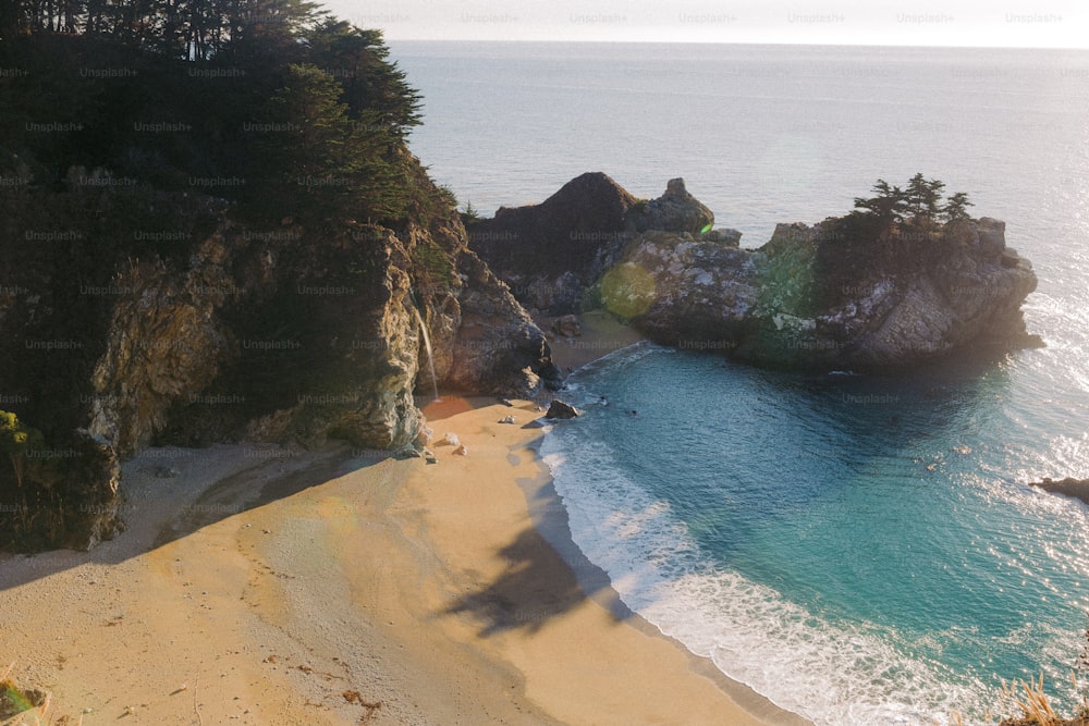 an aerial view of a beach with a cliff in the background