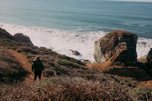 a person walking up a hill near the ocean