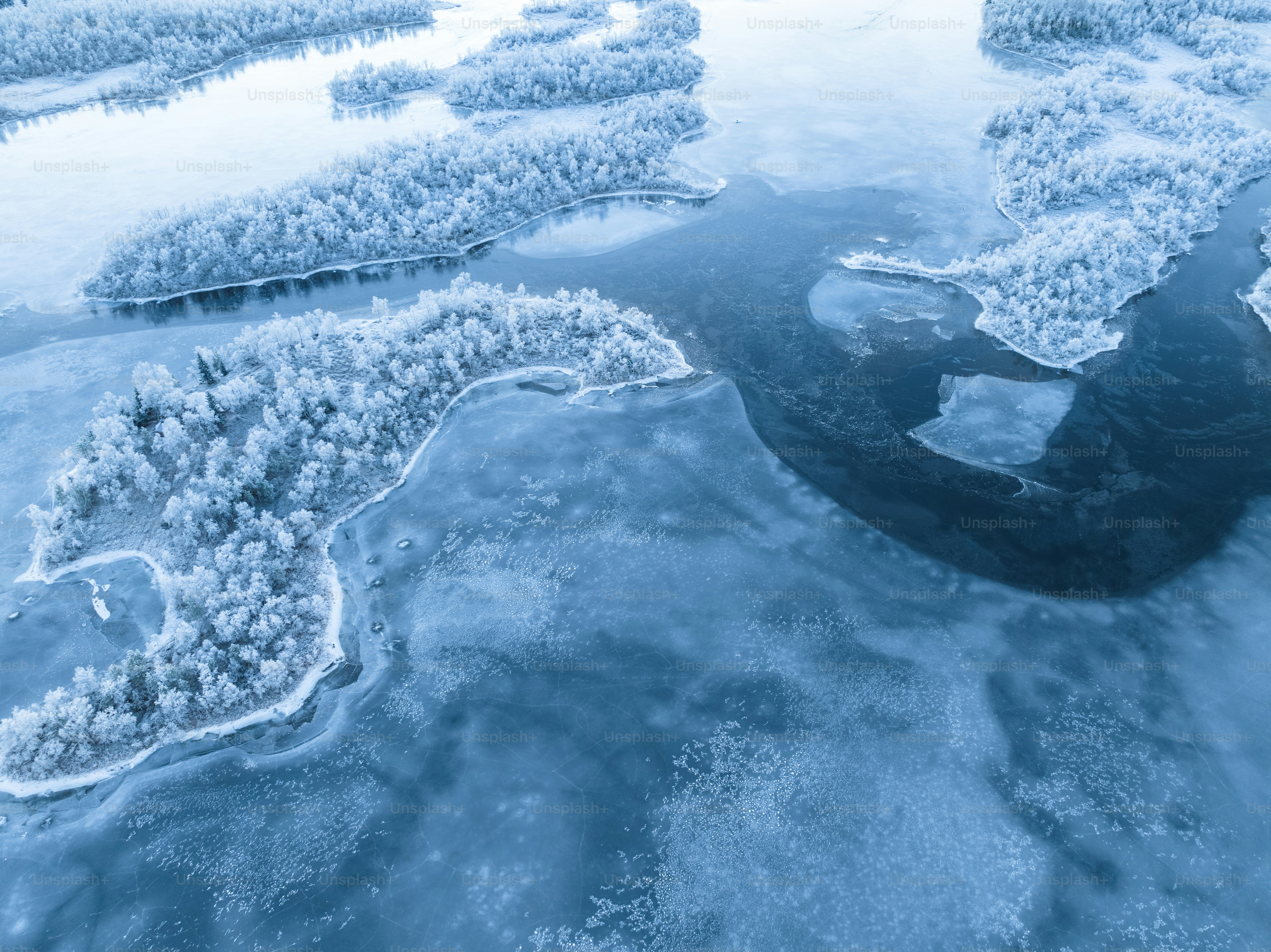an aerial view of a river surrounded by snow