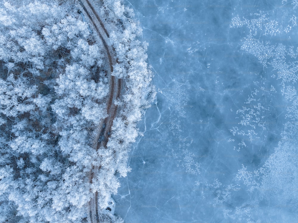 Luftaufnahme einer Bahnstrecke durch den Schnee