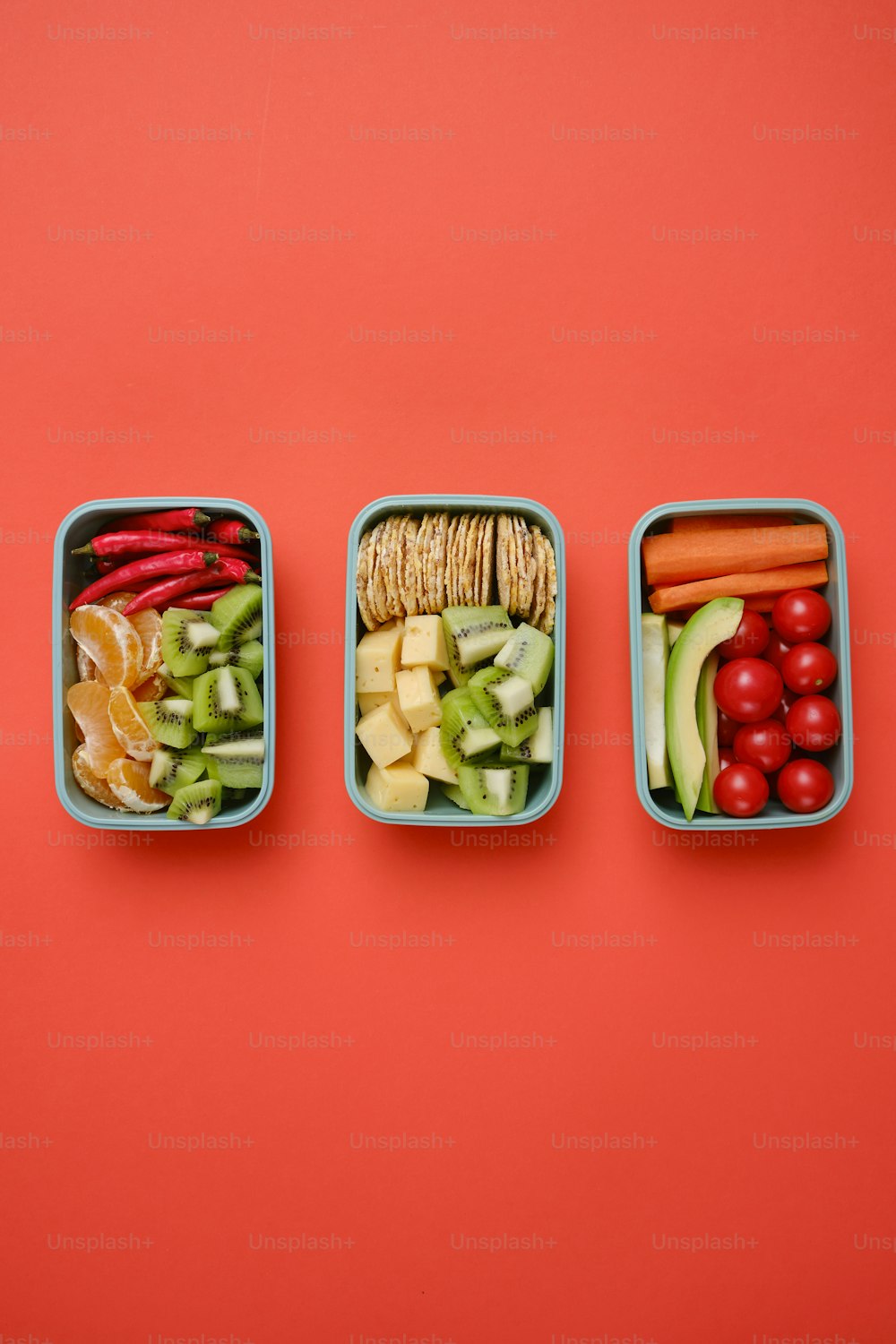 três caixas de bento cheias de diferentes tipos de alimentos