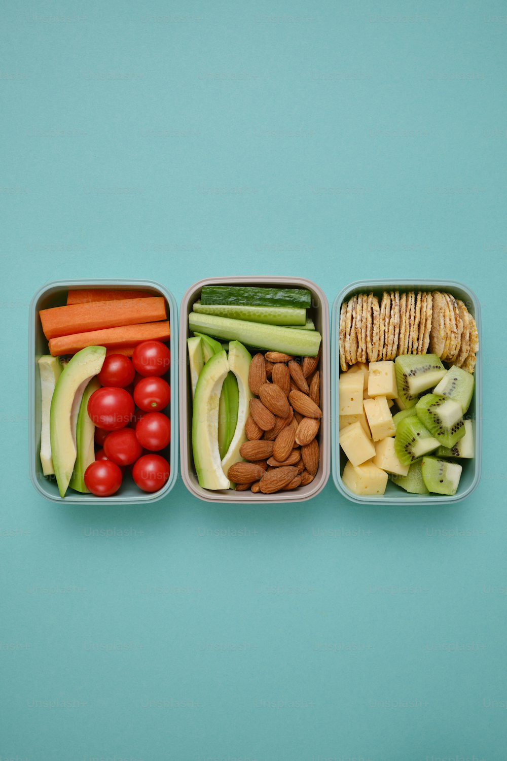 drei Plastikbehälter, gefüllt mit verschiedenen Arten von Lebensmitteln