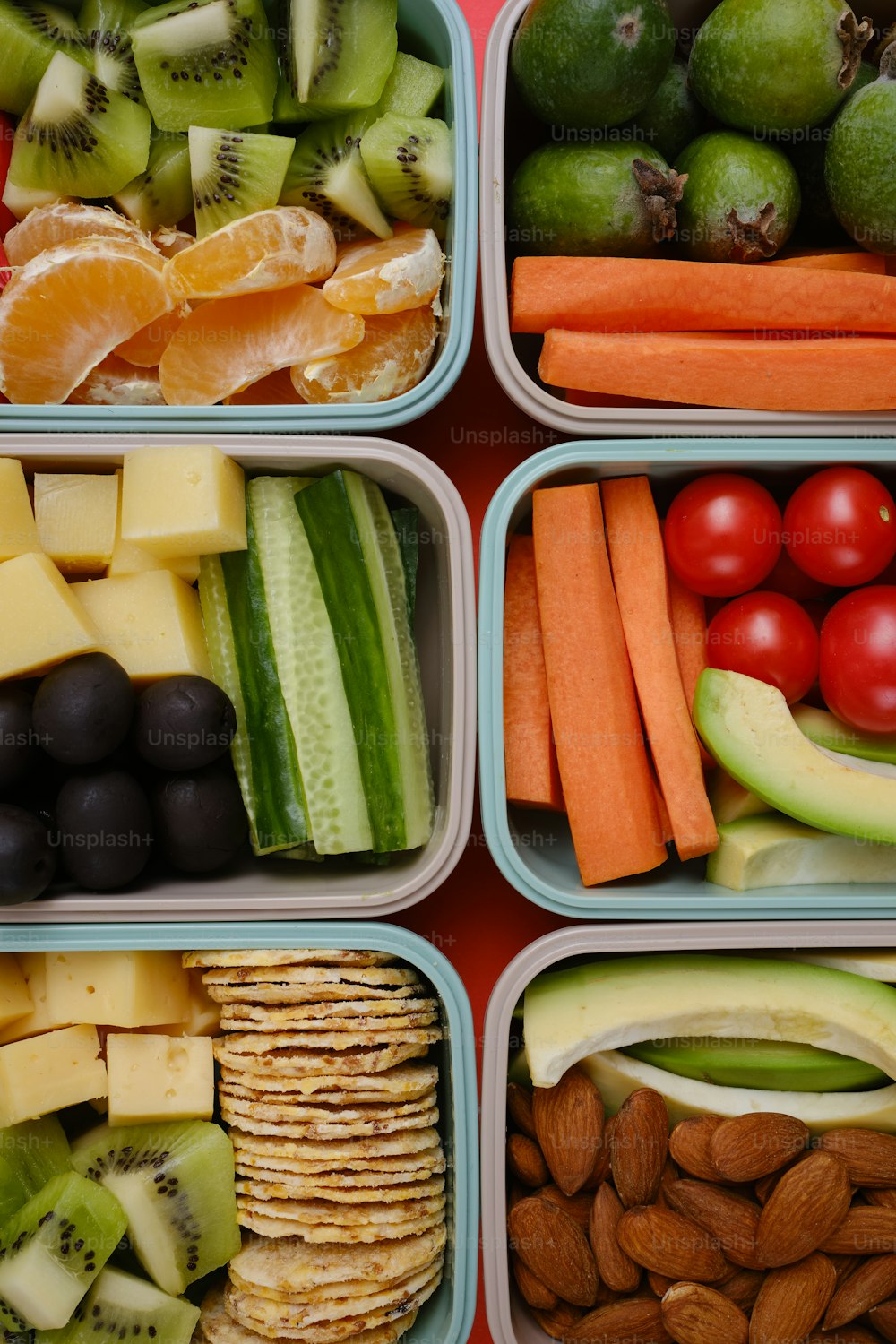 vier Plastikbehälter gefüllt mit verschiedenen Obst- und Gemüsesorten