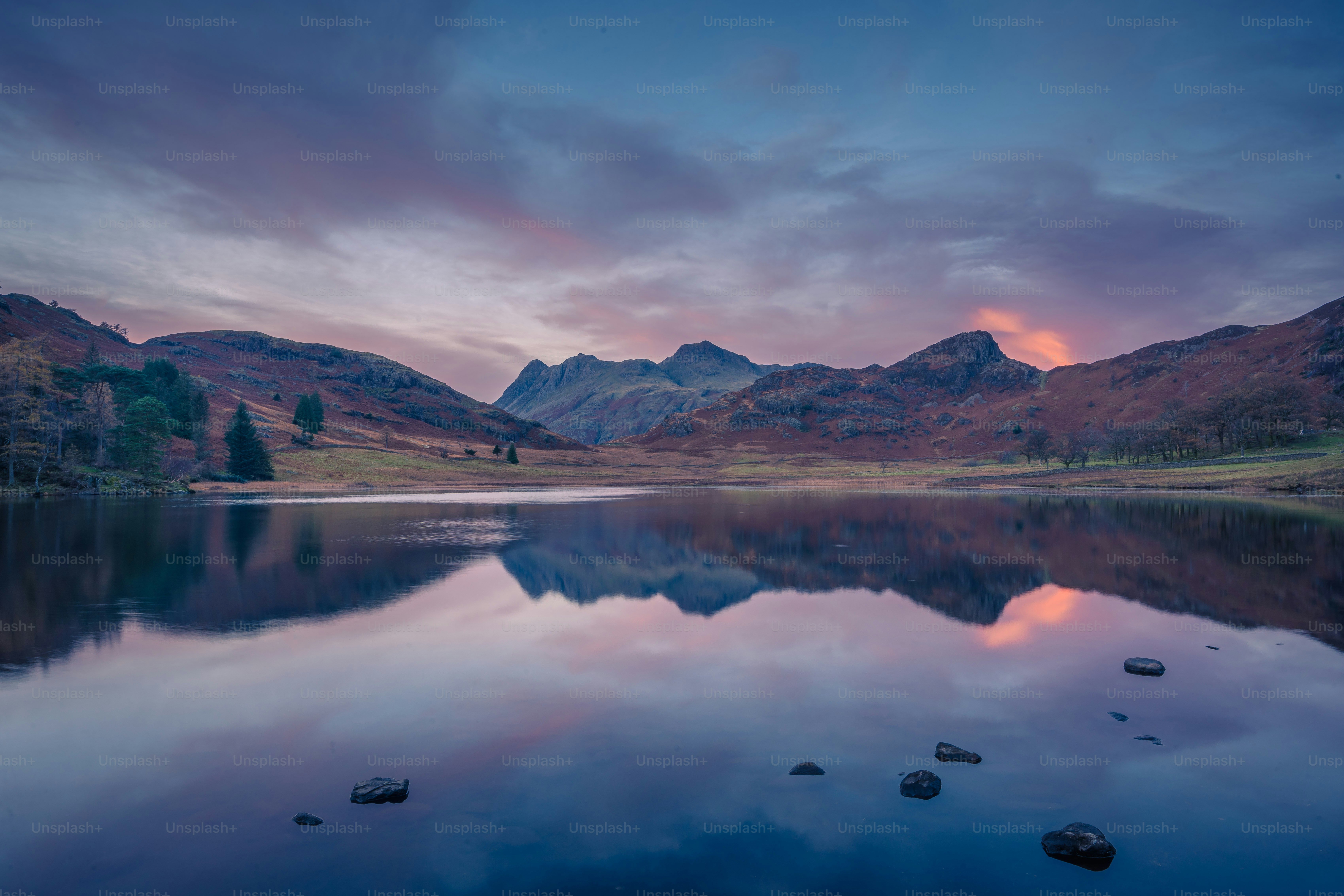 Ein See mit Bergen im Hintergrund bei Sonnenuntergang