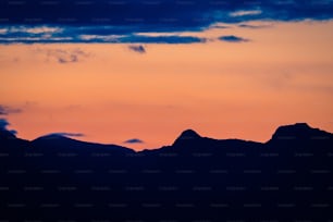 Un avion survolant une chaîne de montagnes au coucher du soleil